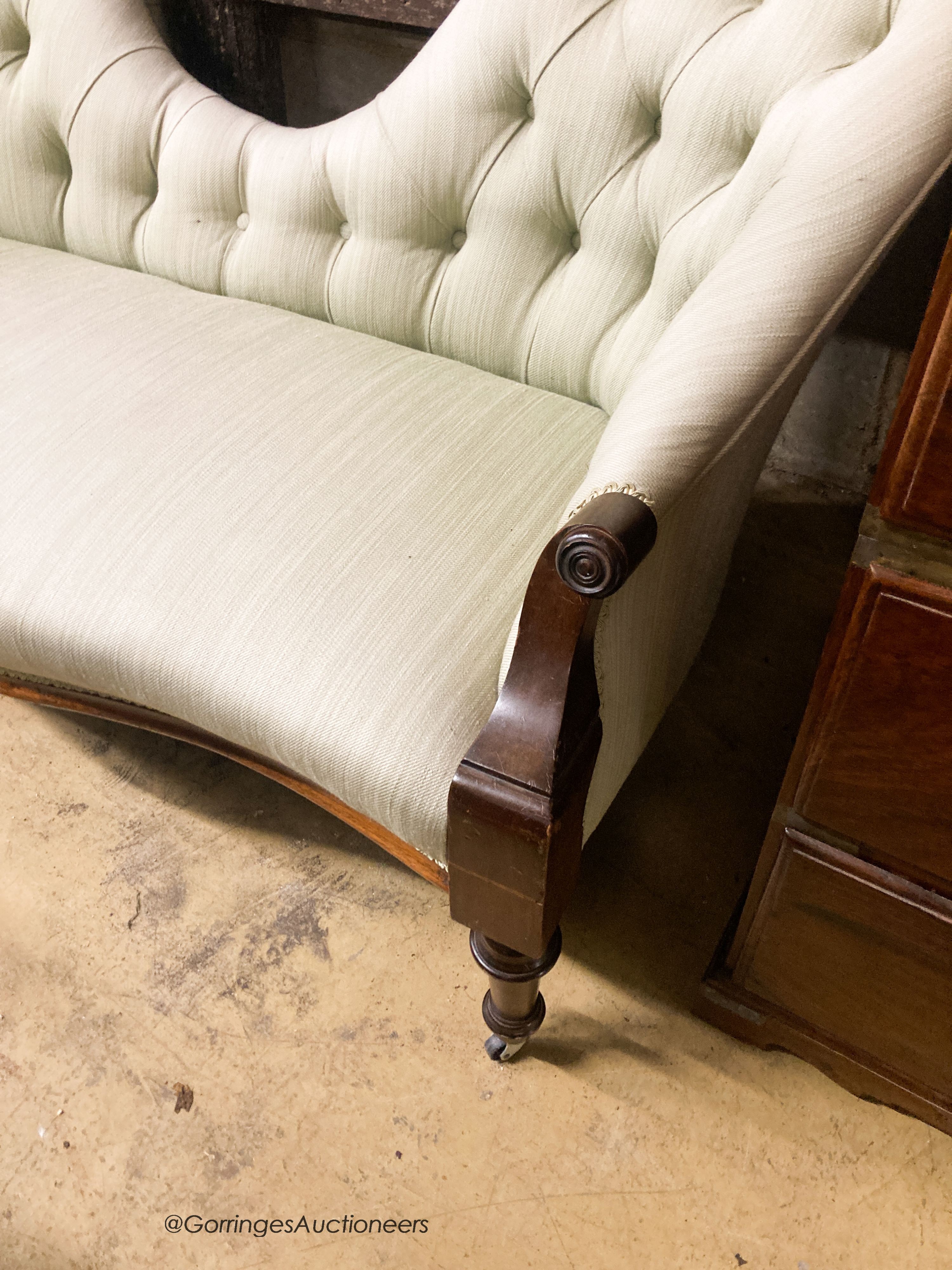 A Victorian mahogany double spoon back settee upholstered in buttoned green fabric, width 130cm, depth 58cm, height 76cm
